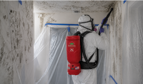 Worker performing mold remediation with HEPA equipment